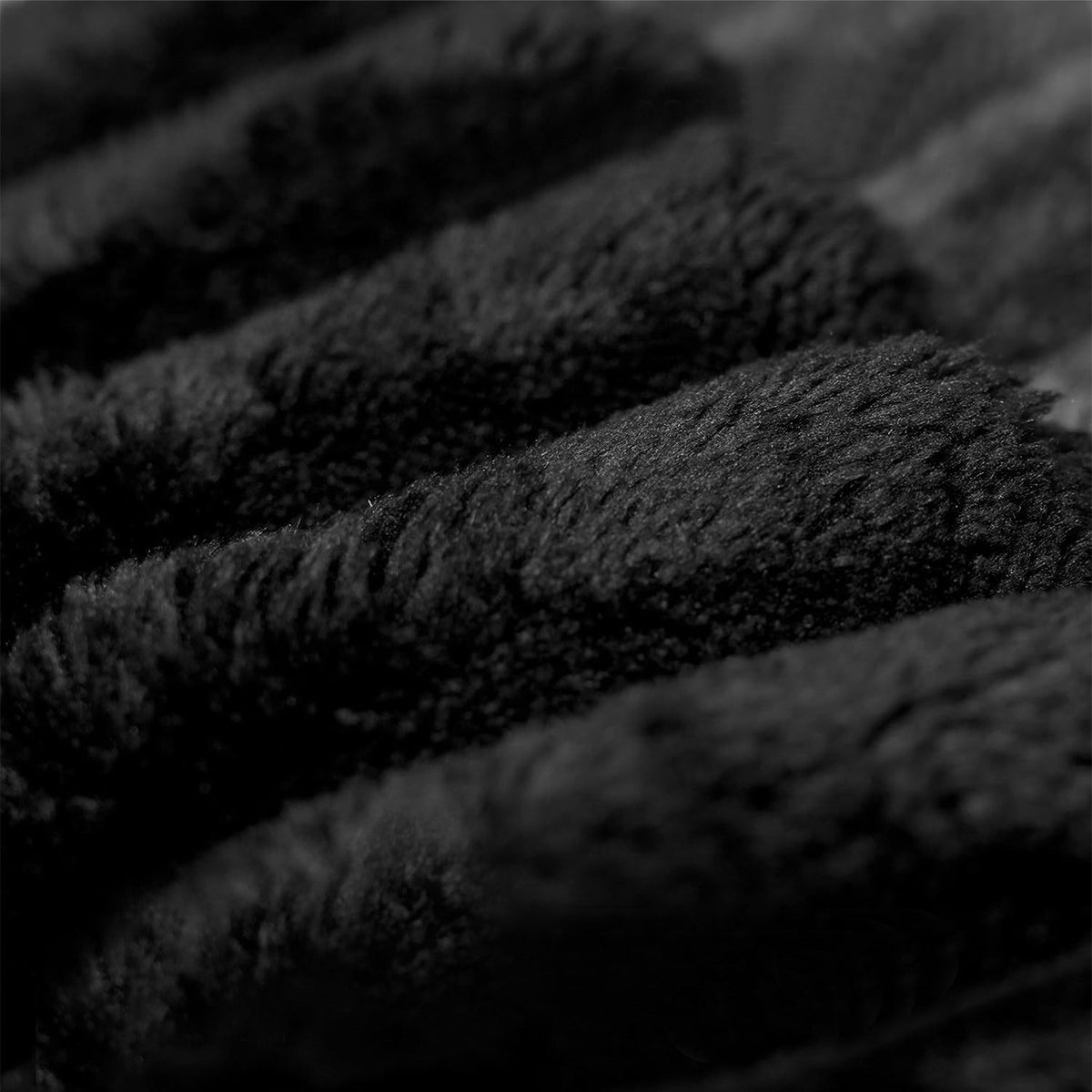 Close-up of dark plush corduroy fabric texture on the sectional sofa upholstery