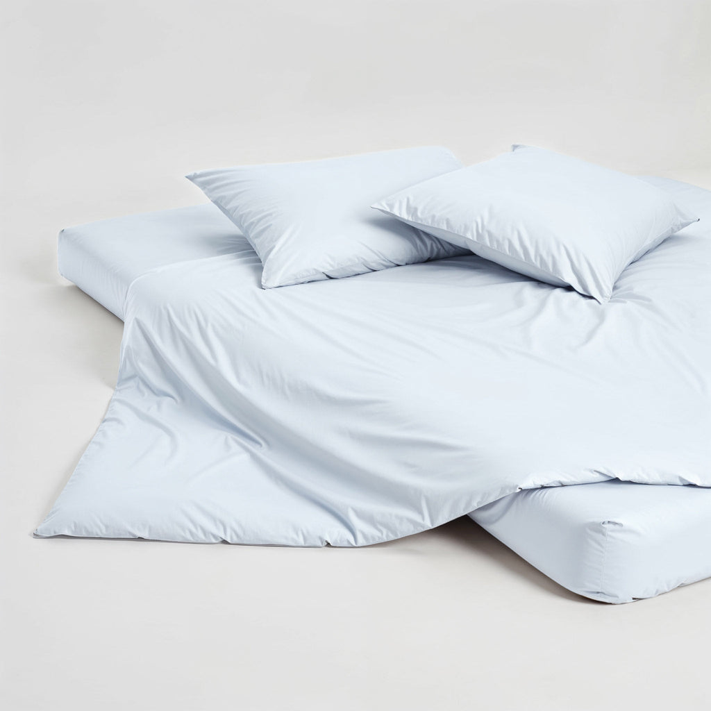 Light blue pillowcase set with two folded pillowcases on a clean white surface