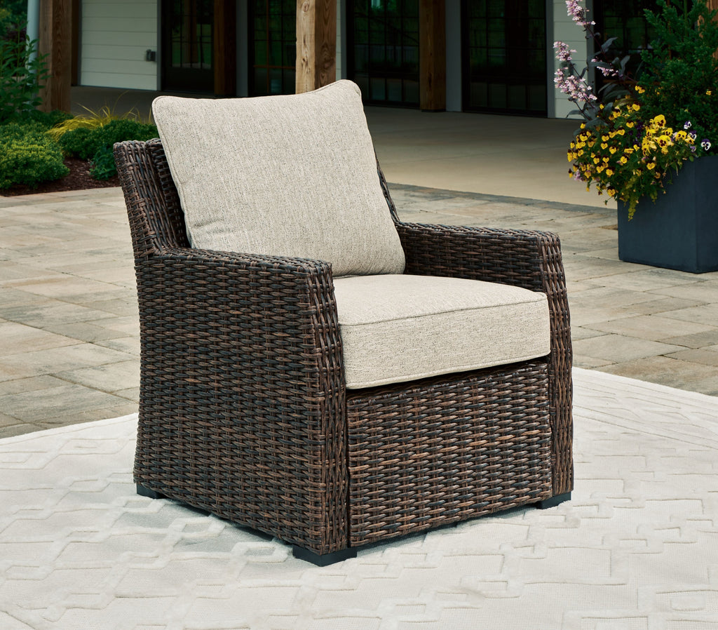 Brown woven lounge chair with beige seat and back cushions