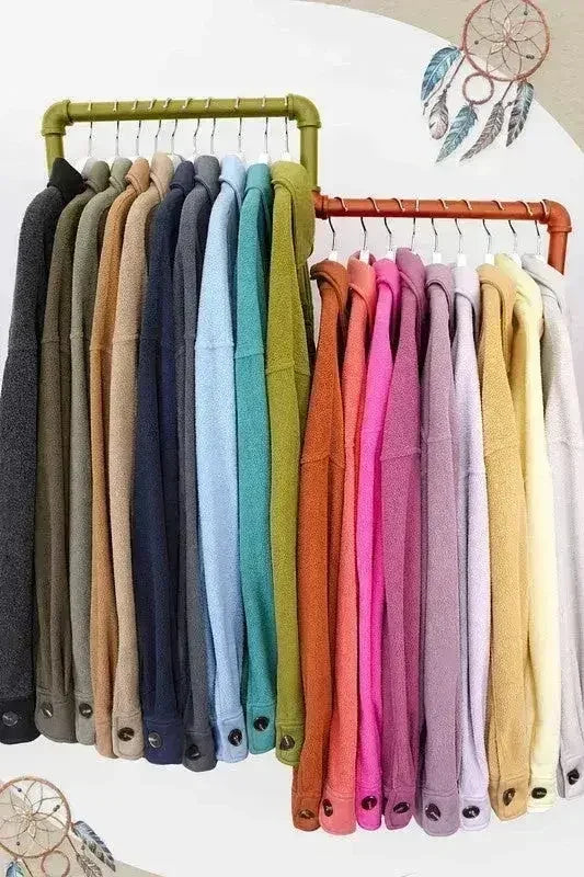 Assorted colors of oversized fleece jackets hanging on two clothing racks