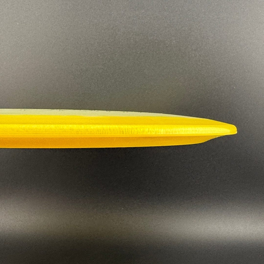 Yellow disc golf disc side view with thin outer rim profile