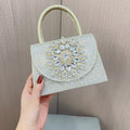 Gold beaded clutch purse with large jeweled floral centerpiece on front flap