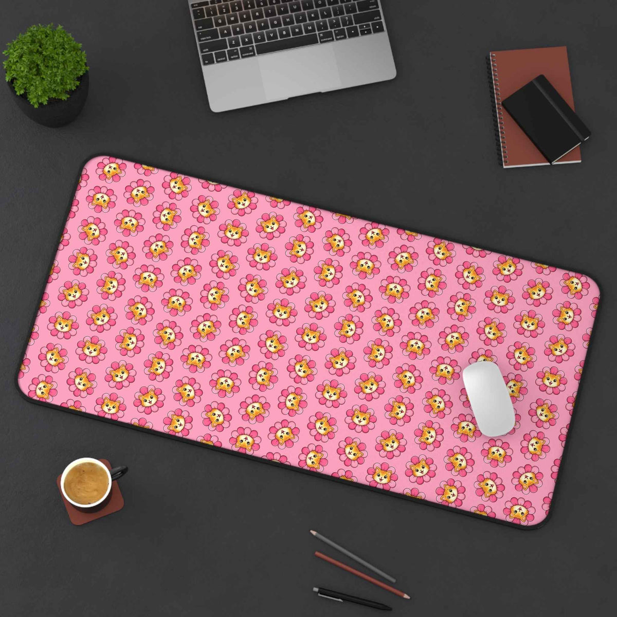 Pink cat-print desk mat with rounded corners, angled view