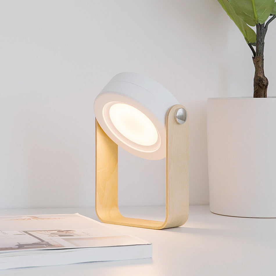 Portable LED lantern with warm light in ribbed shade and light wood frame
