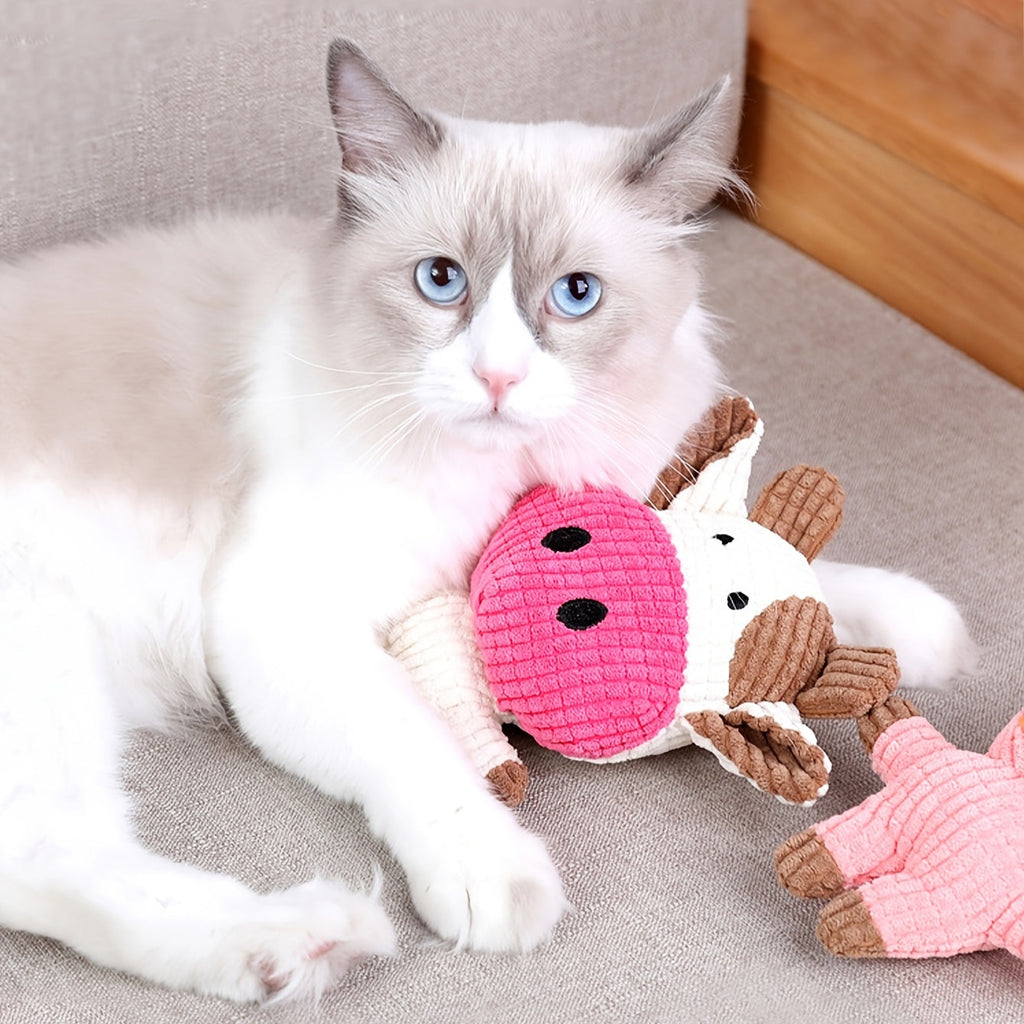 Pink cow-shaped plush dog toy with brown horns and stitched face