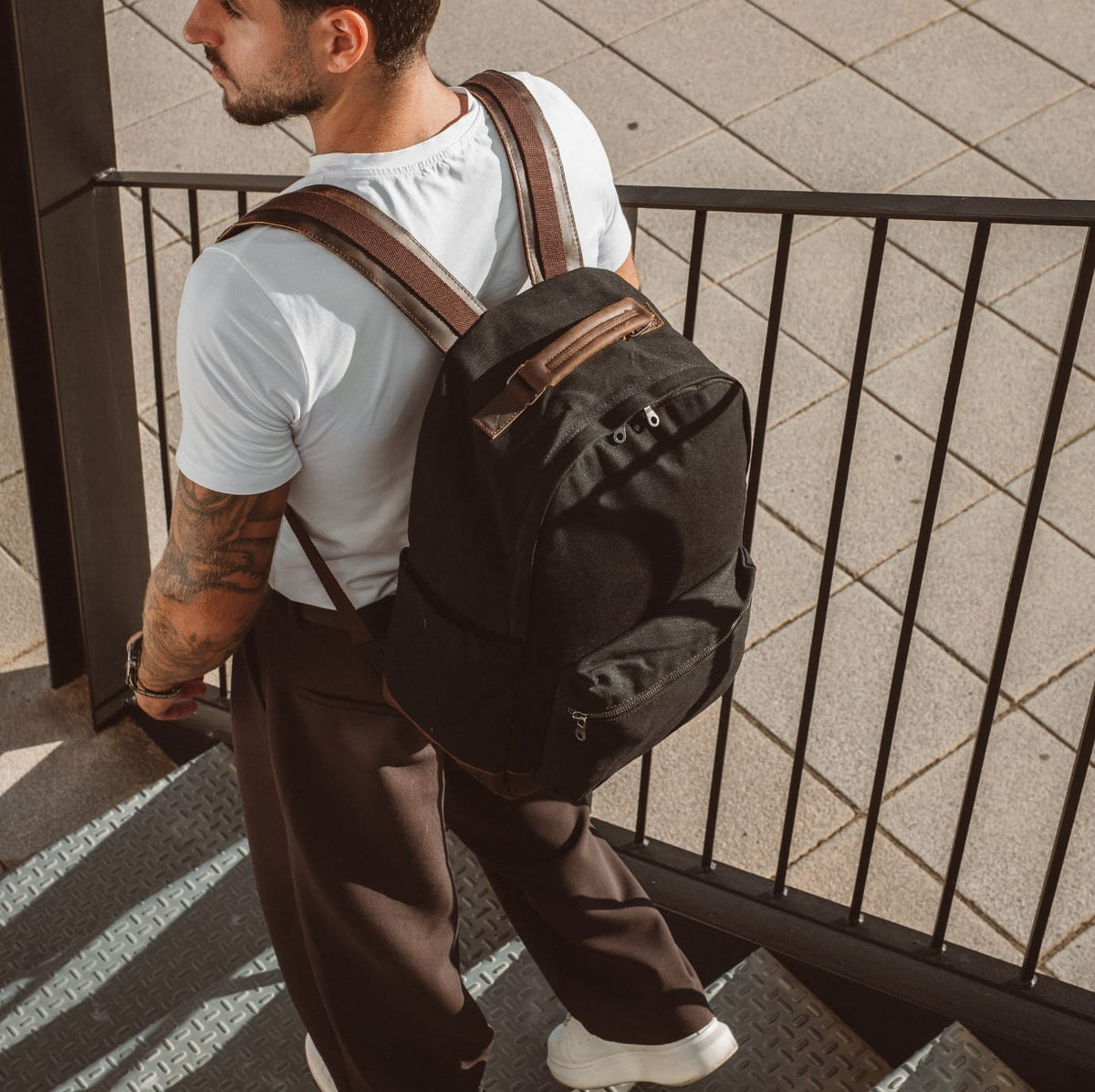 Black backpack with front zip pocket and leather-trimmed shoulder straps