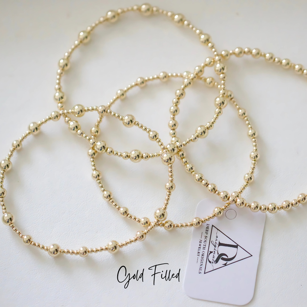 Gold-tone beaded bracelet with round beads and linked chain design