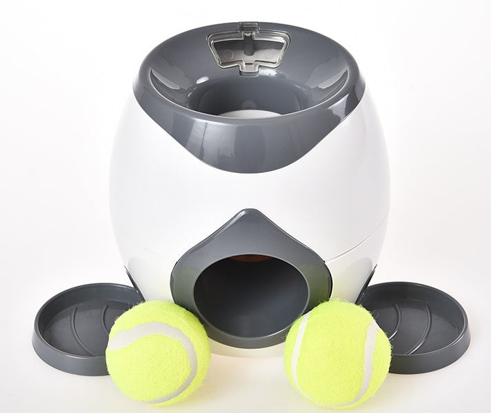 White smart pet feeder with open top and side ball chute, two tennis balls