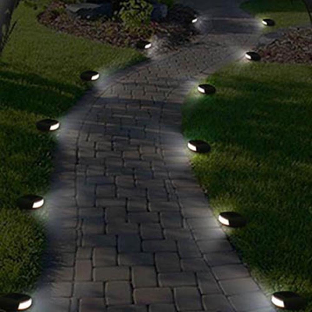 Grey solar cobblestone path lights lining a garden walkway