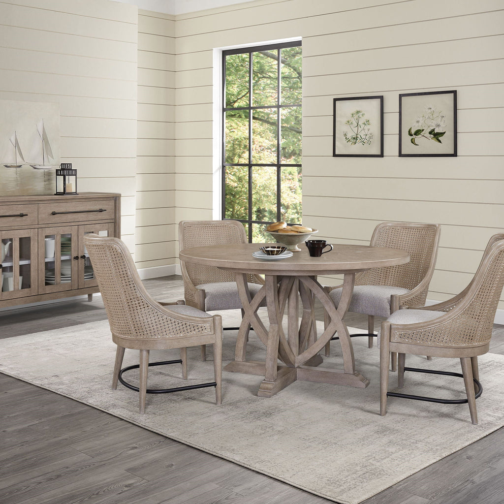 Round extendable dining table with sand finish and pedestal base in a dining room