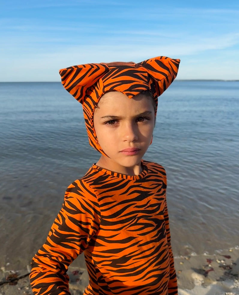 Orange-and-black tiger-print hooded costume with ears, worn by child outdoors