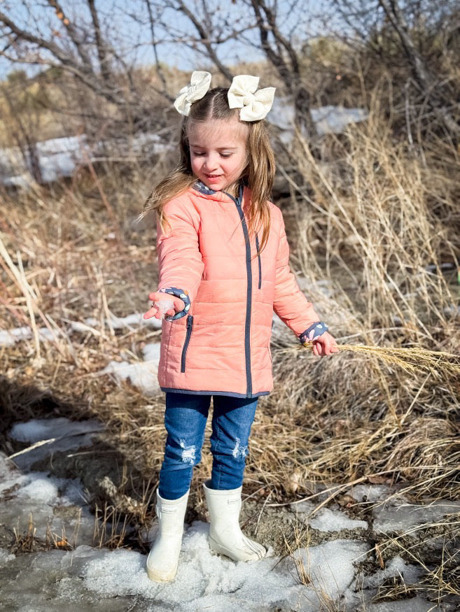 Kids lightweight puffy jacket, peach orange front view with black zipper