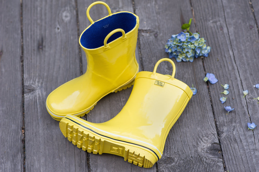 Yellow rain boots with navy interior and textured tread sole
