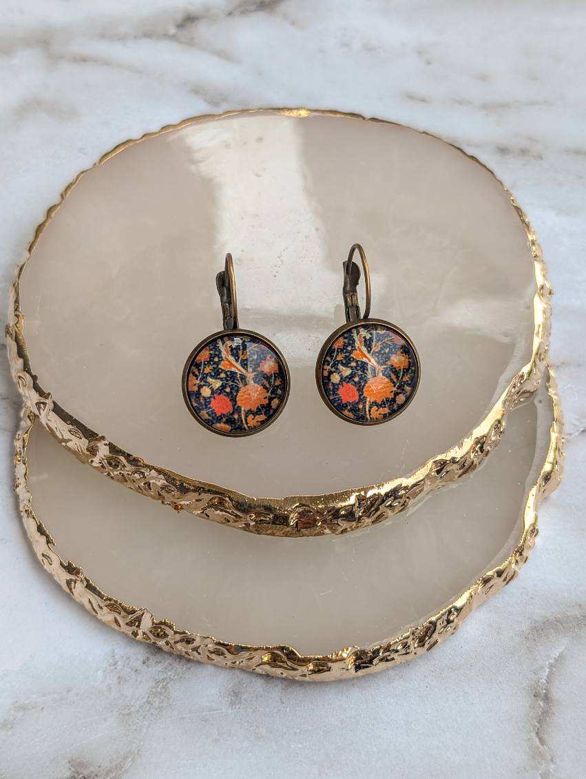 Round floral leverback earrings with orange and blue botanical pattern on bronze hardware.