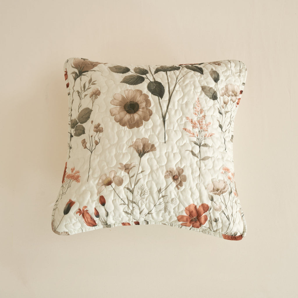 Floral quilt pillow in off-white with dense quilting and botanical print in beige and rose.
