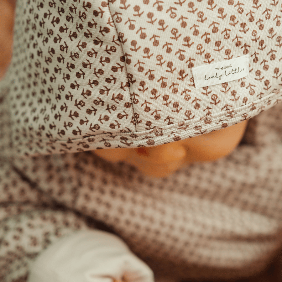Light pink printed baby jacket close-up: hood drawstring tie and gathered hem