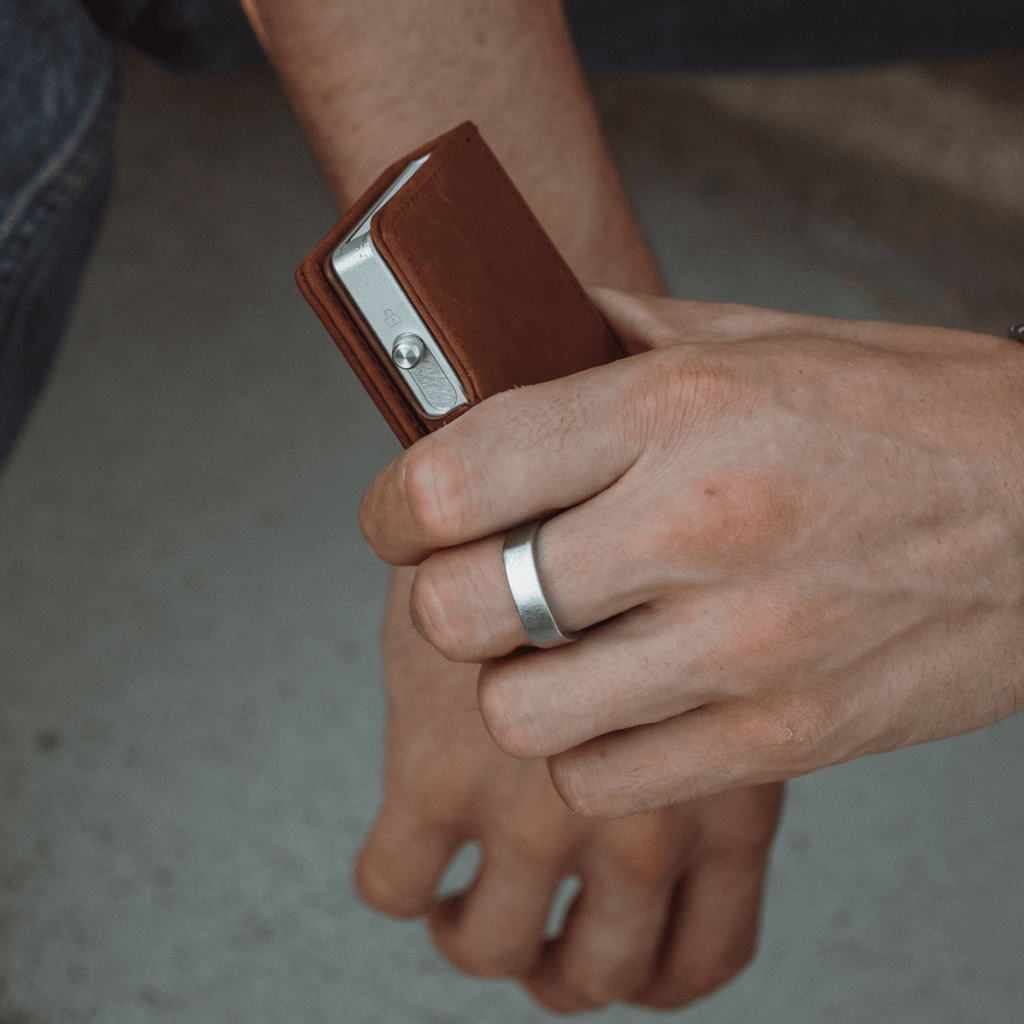 Brown leather bifold wallet close-up showing metal clasp and card holder