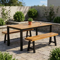 Acacia wood rectangular patio dining table with two matching benches and dark legs.