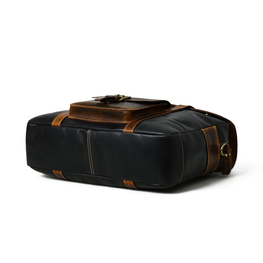 Black leather duffel-style travel bag with brown top handle, brass clips, and side straps
