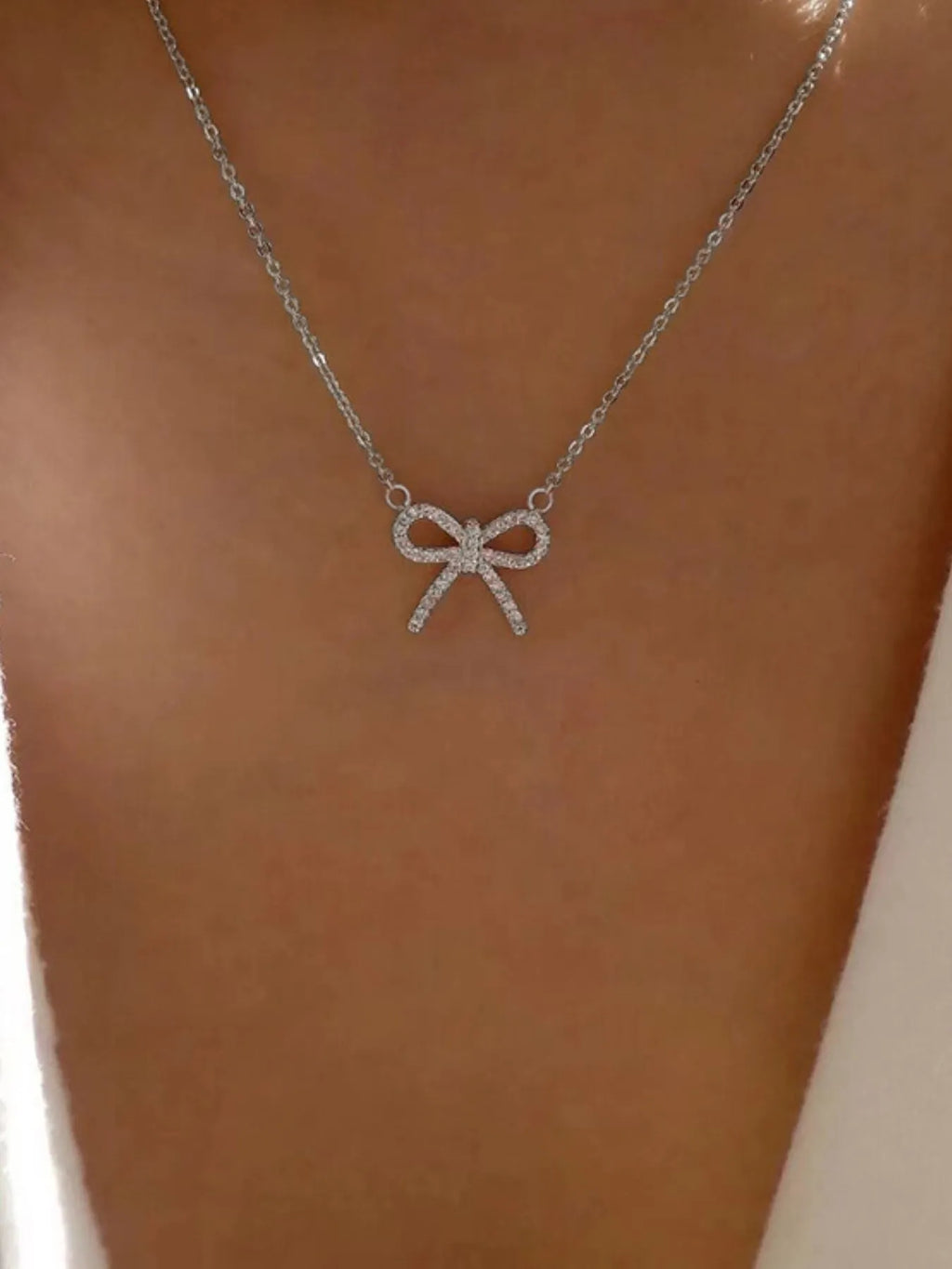 Silver knot pendant necklace with clear rhinestone bow and short chain