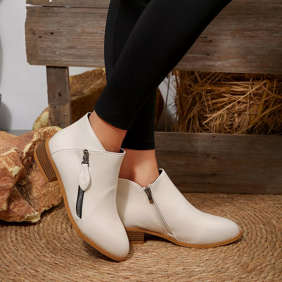 White block-heel ankle boots with side zipper and tan outsole