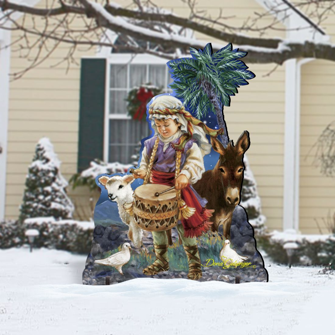 Nativity outdoor decor with drummer boy holding drum, donkey, cow, and blue palm tree
