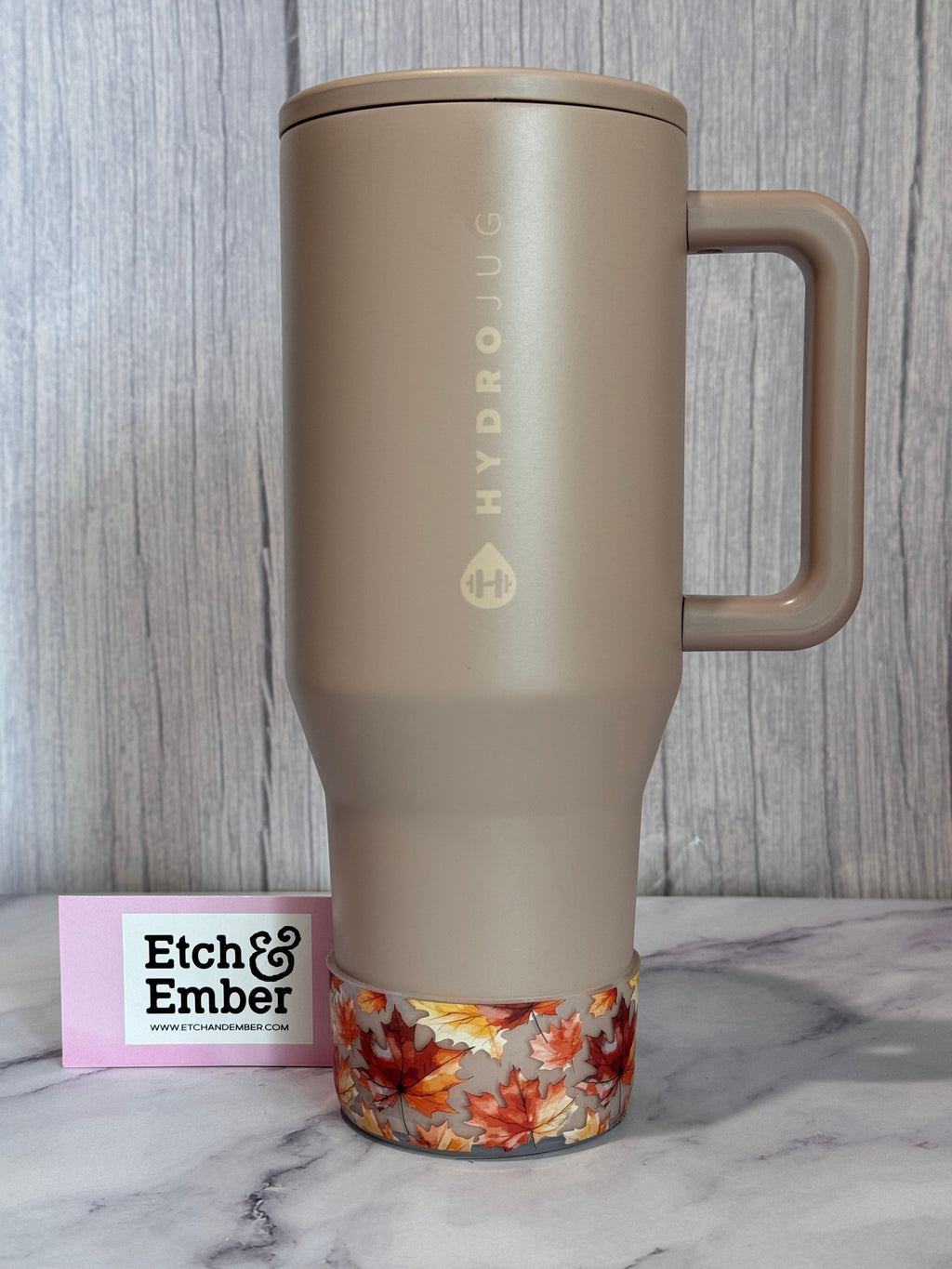 Transparent fall-leaves bottle boot wrap at bottom on beige bottle, orange maple leaves