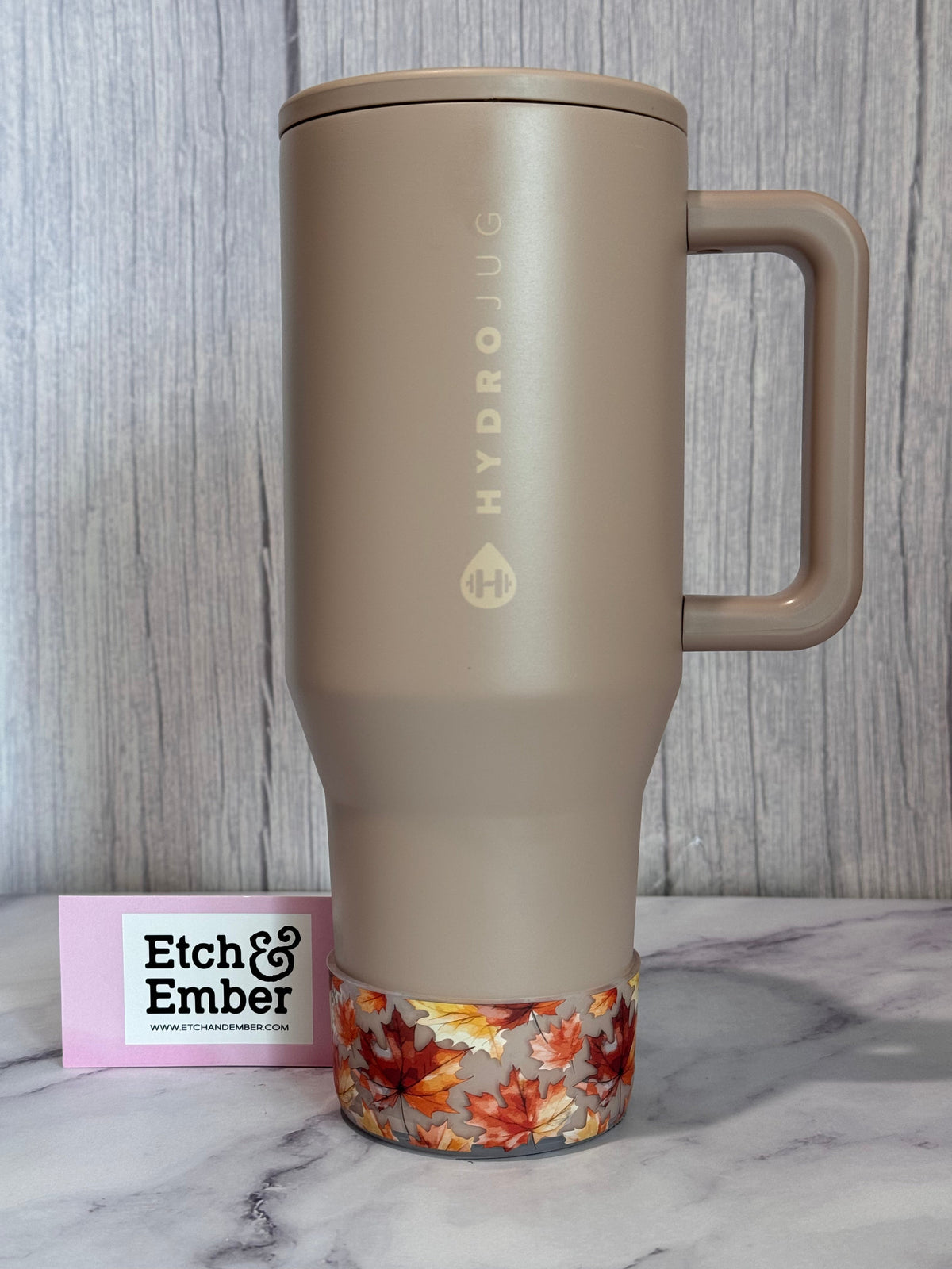 Transparent fall-leaves bottle boot wrap at bottom on beige bottle, orange maple leaves