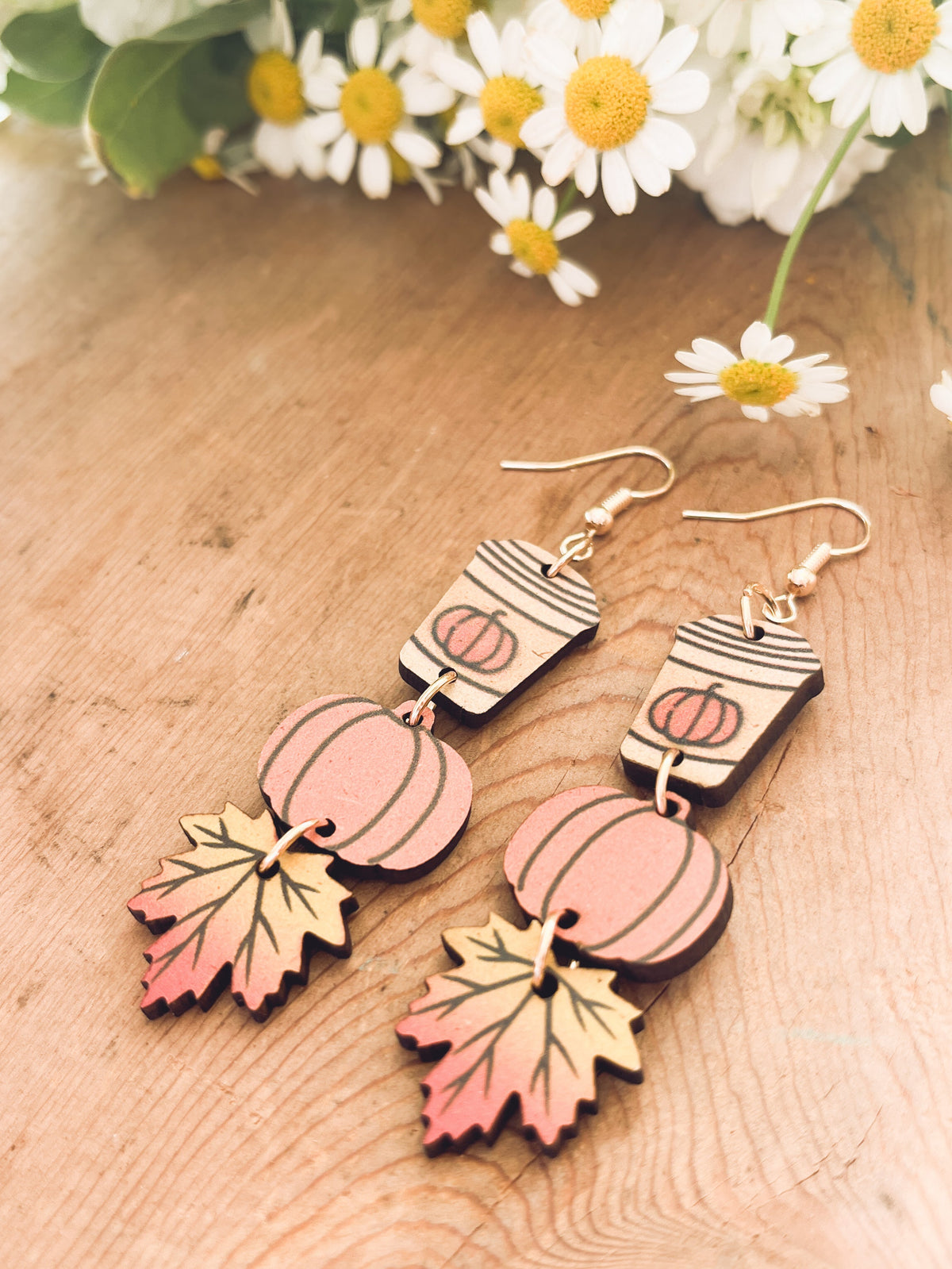 Pair of wood dangling earrings with painted coffee cup, pumpkin, and autumn leaf