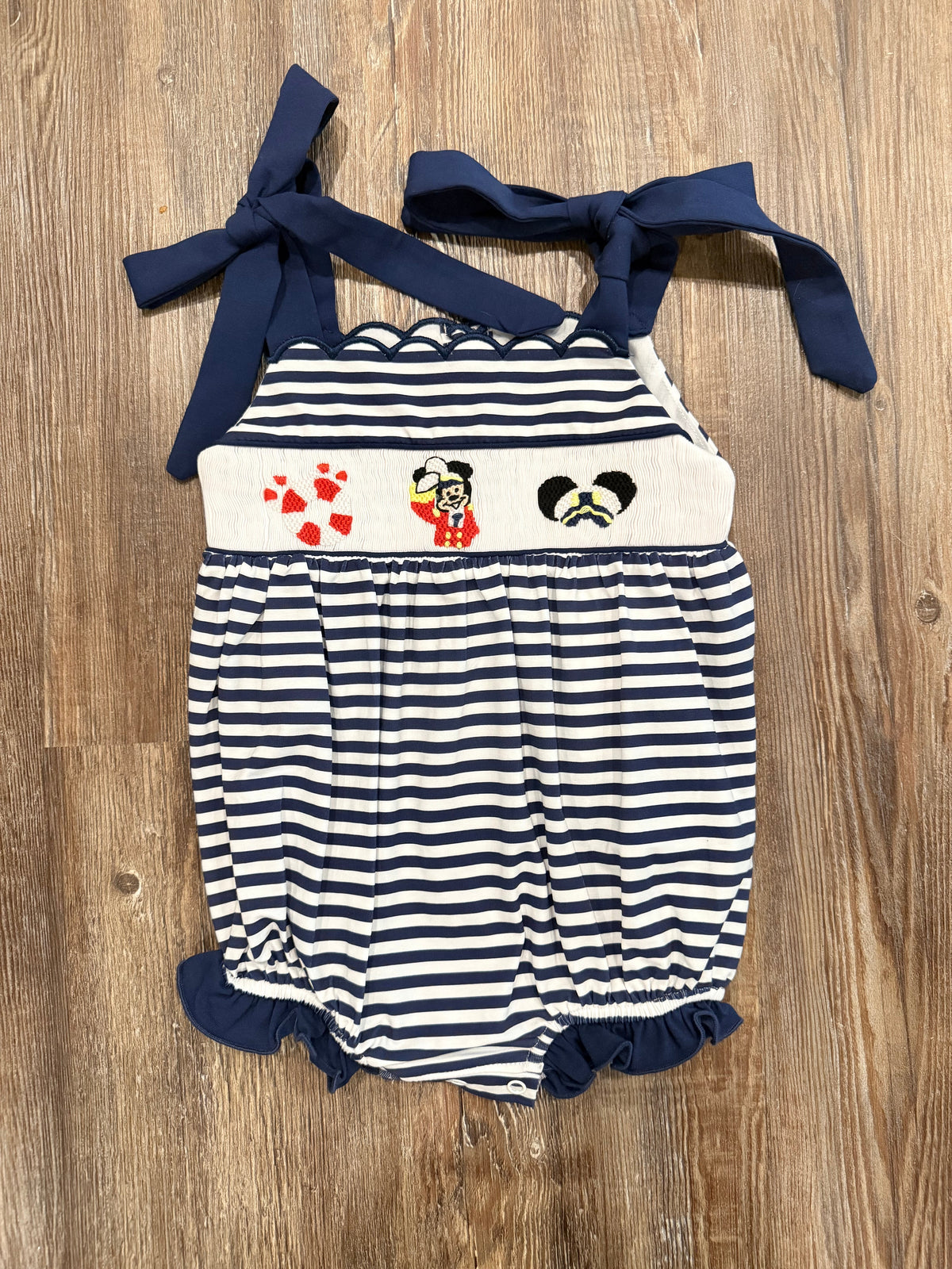 Navy-and-white striped baby romper with character applique and navy ribbon shoulder ties