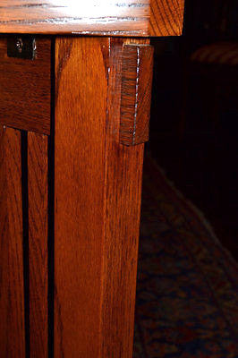 Detail of dark wood plant stand leg corner with visible grain and joinery