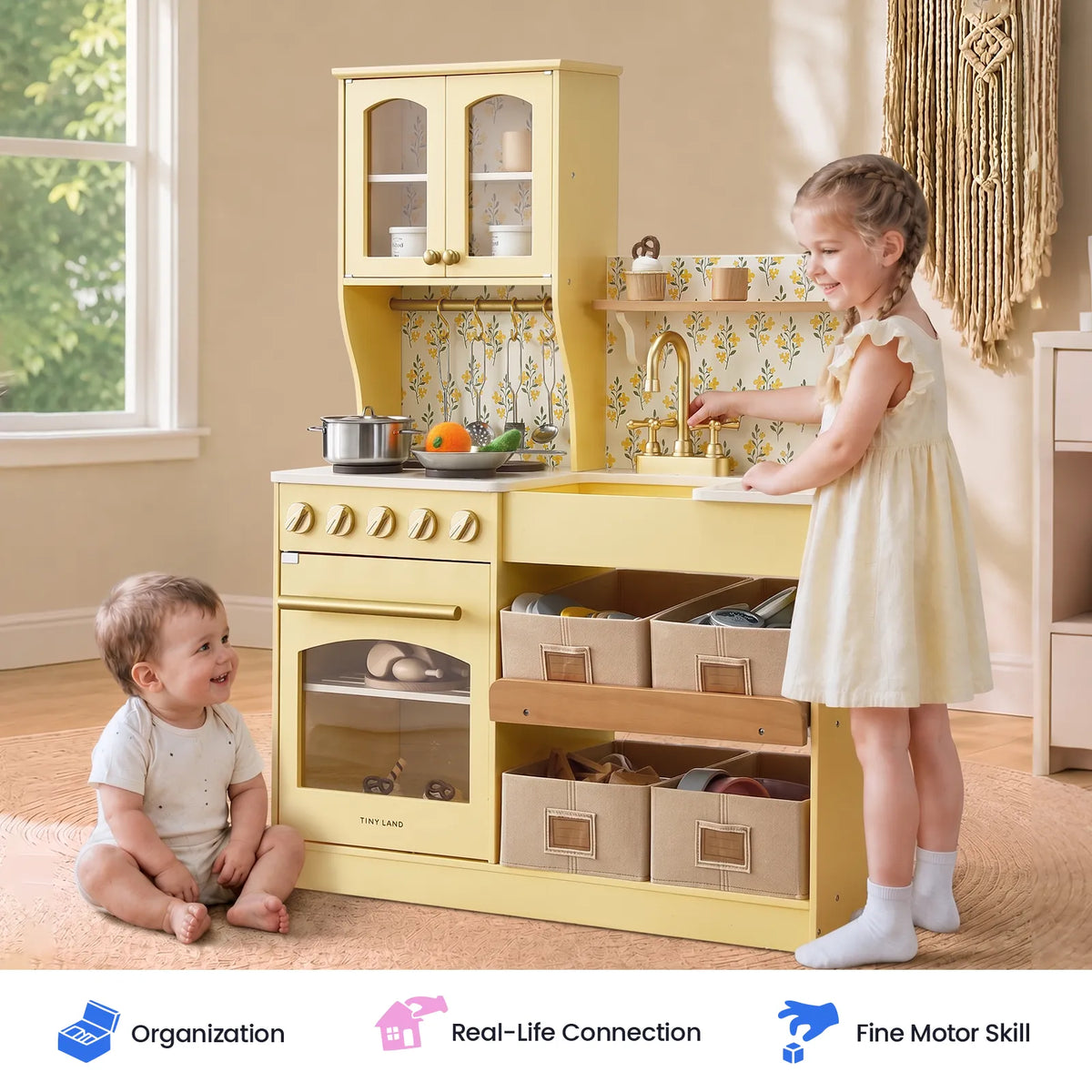 Yellow wooden play kitchen with child at the sink and open storage drawers