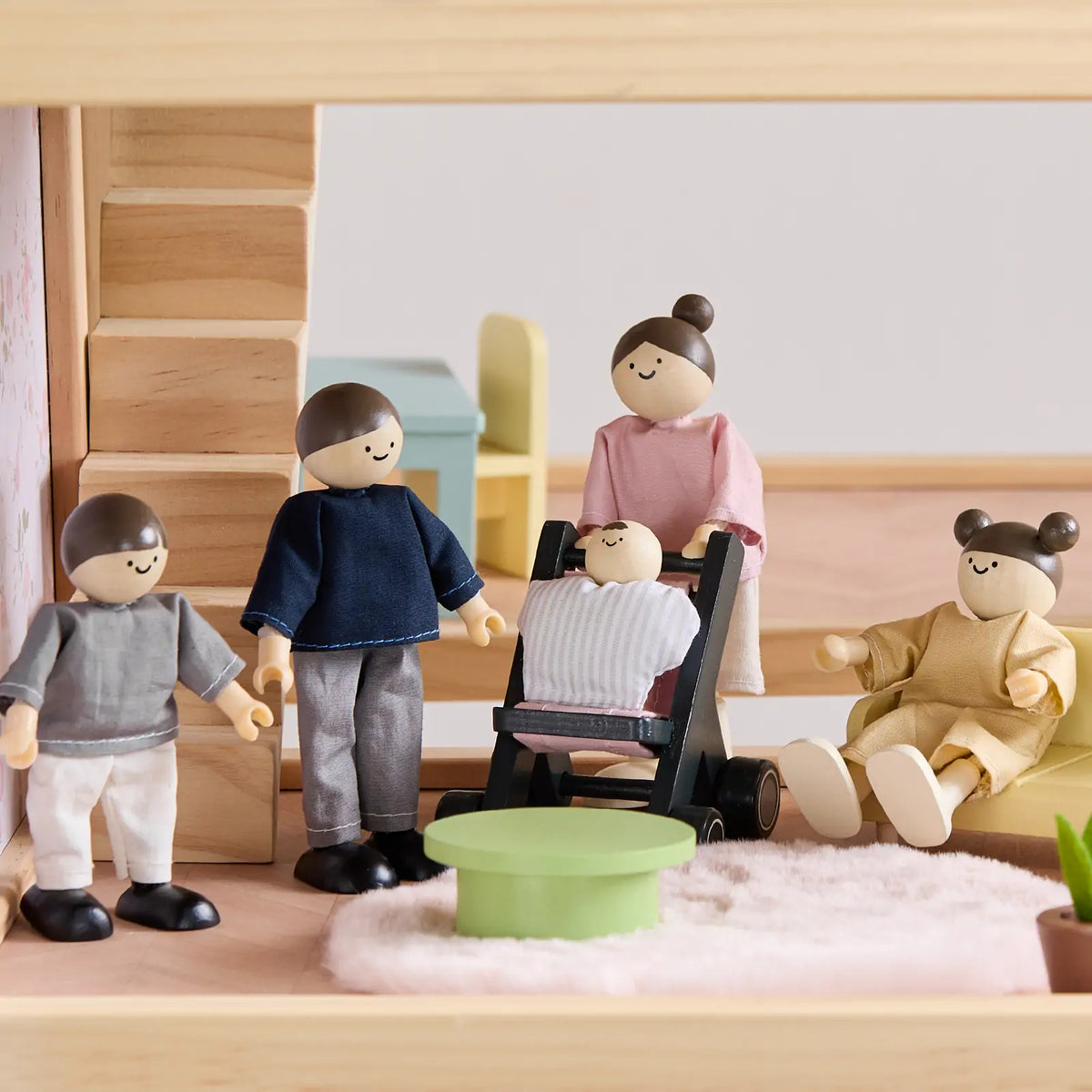 Mini family dolls with stroller accessory inside the wooden dollhouse room