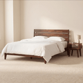 Wood bed frame with white bedding and matching side nightstand, dark tapered legs