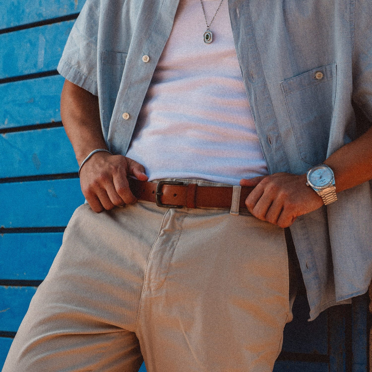 Brown leather stretch belt with metal buckle and keeper holes