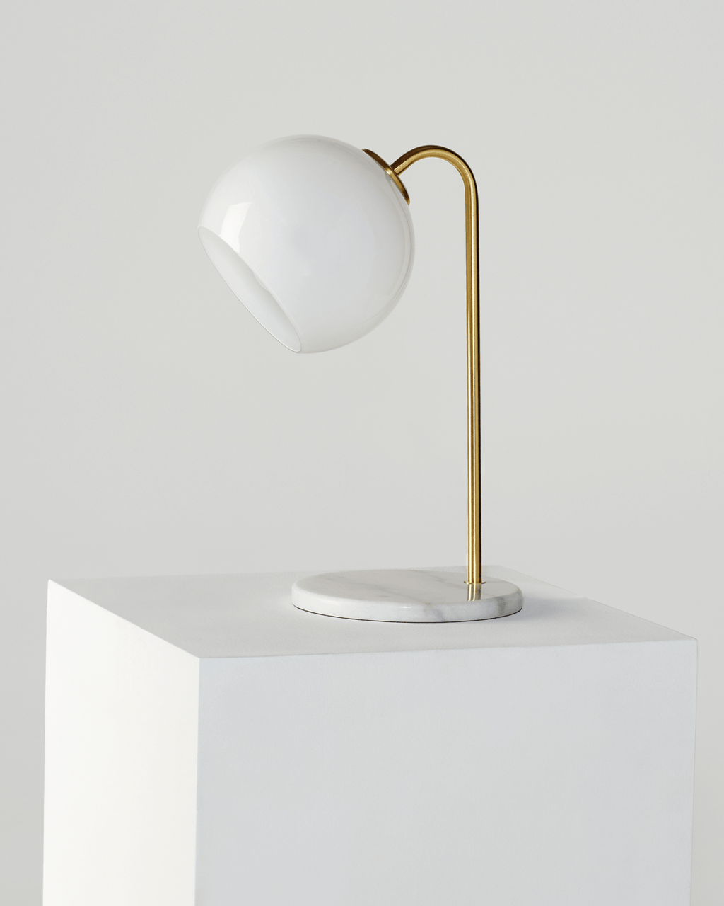 Krystal table lamp on white square pedestal with gold stem and opal shade