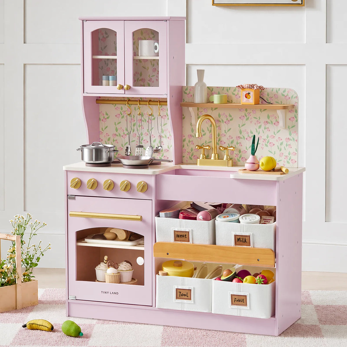Light pink wooden play kitchen with sink, stove, and open storage cubbies
