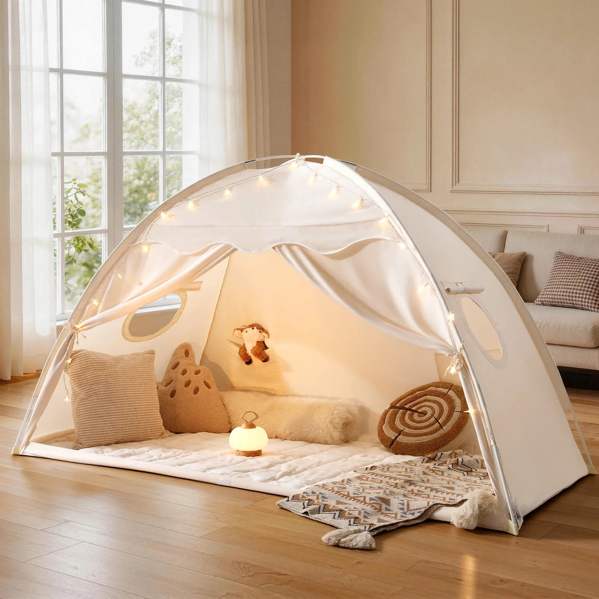 Pink kids bed tent with hanging lights, pillows, and soft play bedding