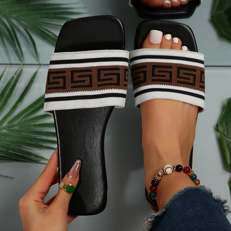 Open-toe slide sandals with black footbed and striped patterned fabric straps