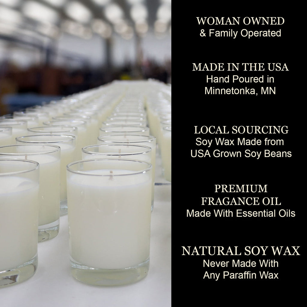Rows of white jar candles with wicks, displayed in glass containers