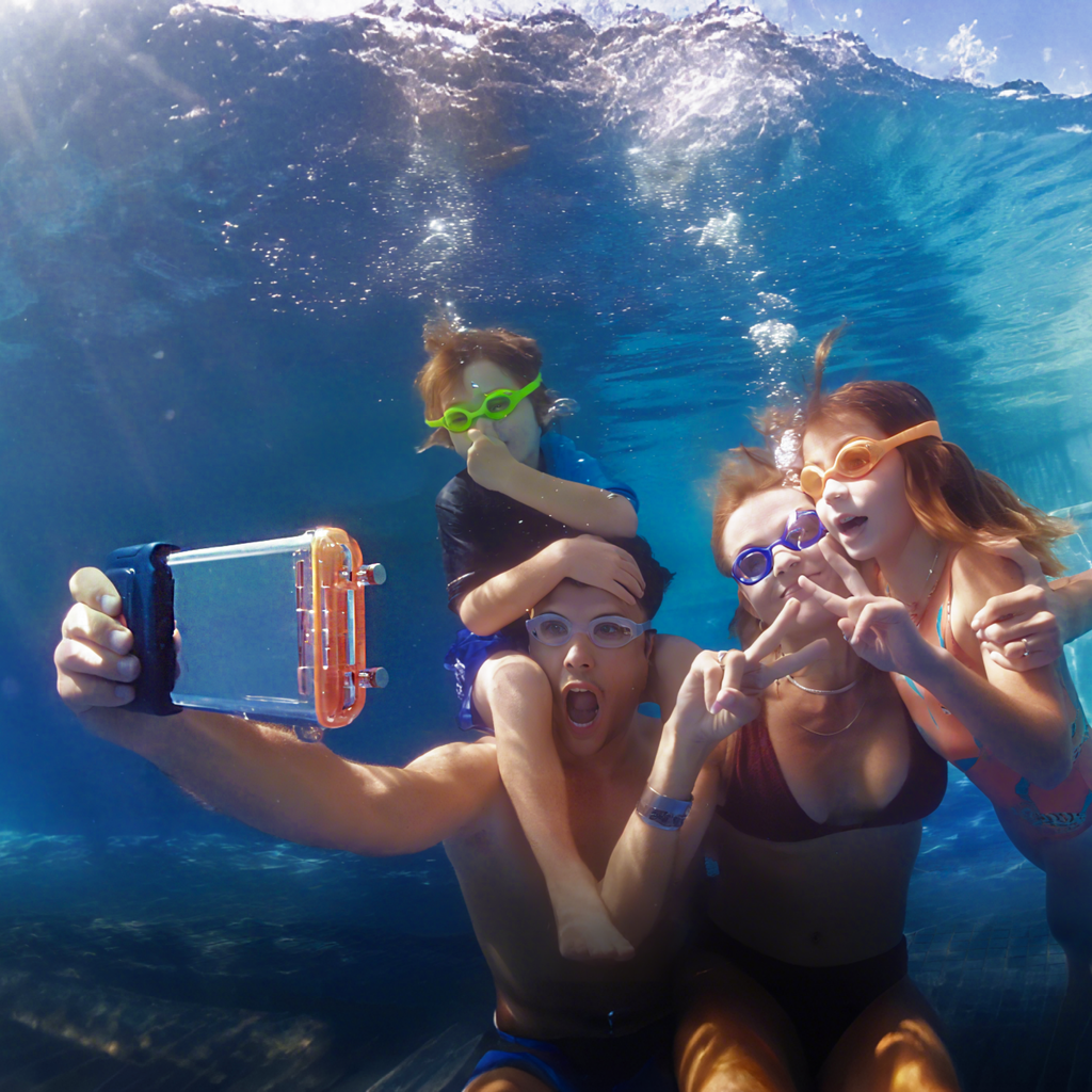 Clear waterproof phone case with orange control section, held underwater by swimmers