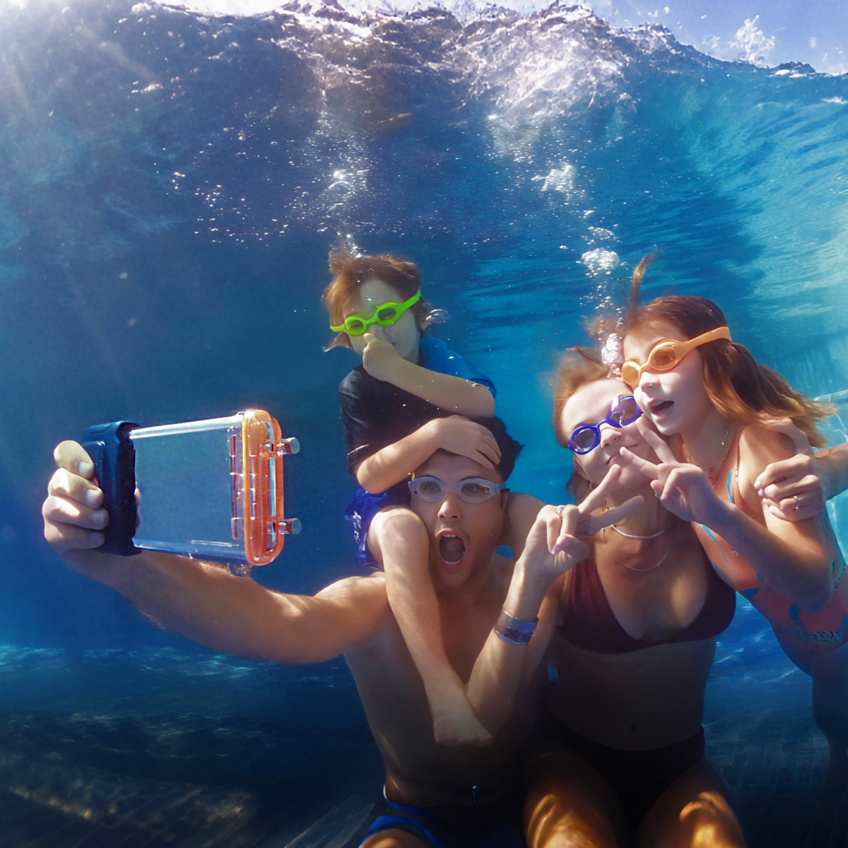 Clear waterproof phone case with orange control section, held underwater by swimmers