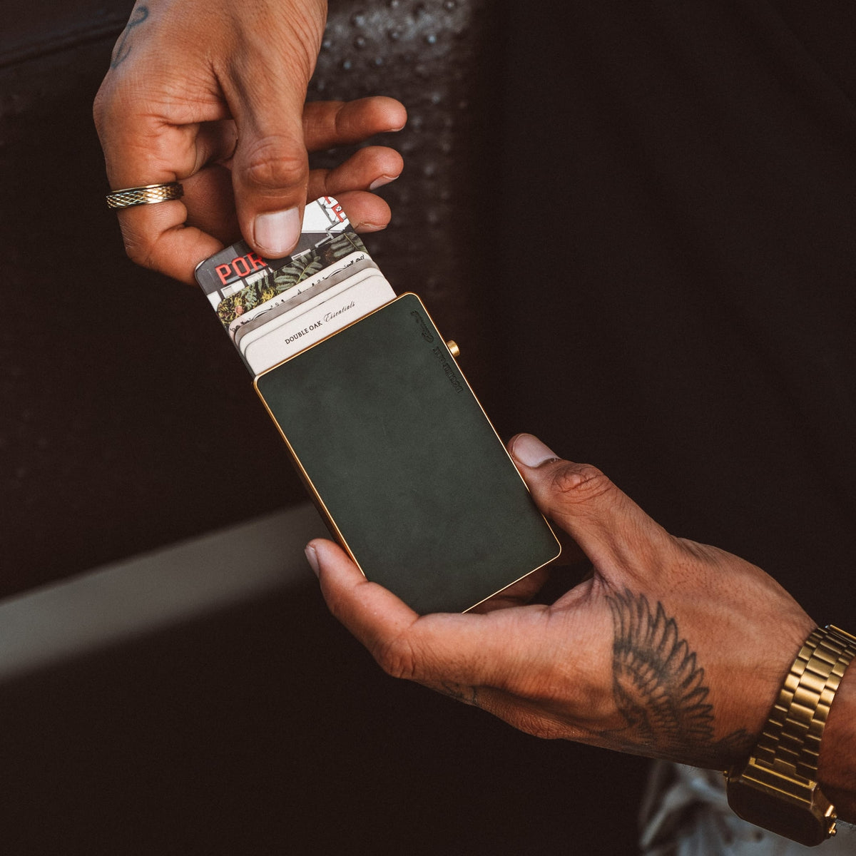 Mod wallet cardholder open with cash and card stack inside dark holder, gold-tone frame shown