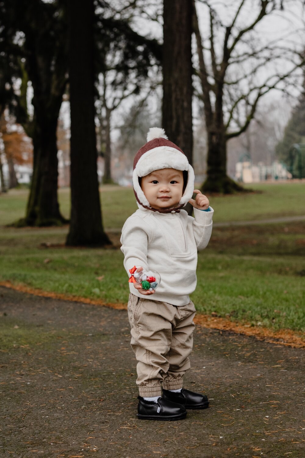 Kids trapper hat with white faux fur trim, red knit crown, and ear flaps