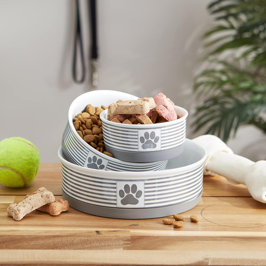Stacked striped ceramic pet bowls filled with kibble and treats