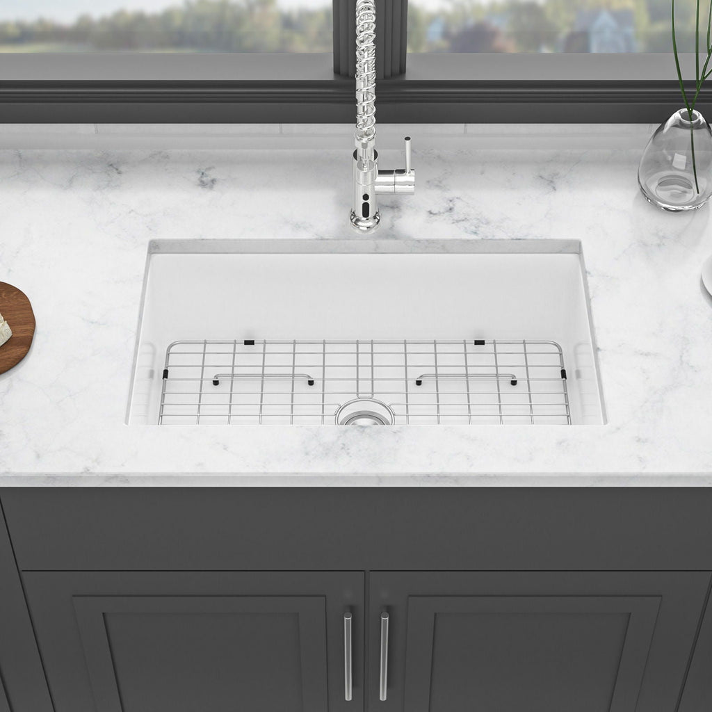 White ceramic single-bowl apron-front sink with wire rack and drain strainer