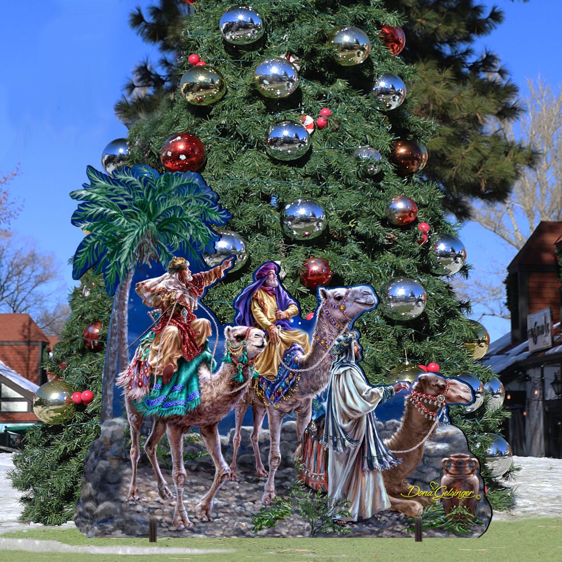 Outdoor nativity scene with three kings on camels beside a palm tree centerpiece