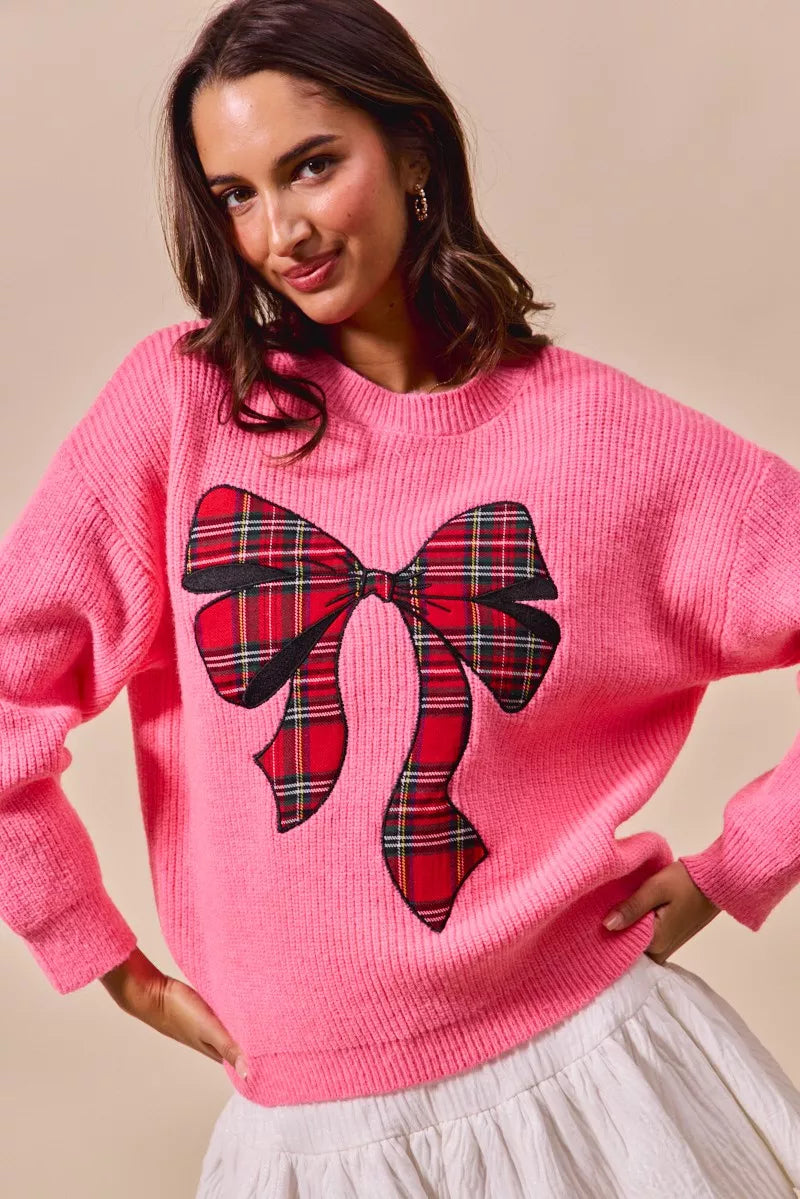 Pink sweater with plaid ribbon bow graphic and slightly cropped hem