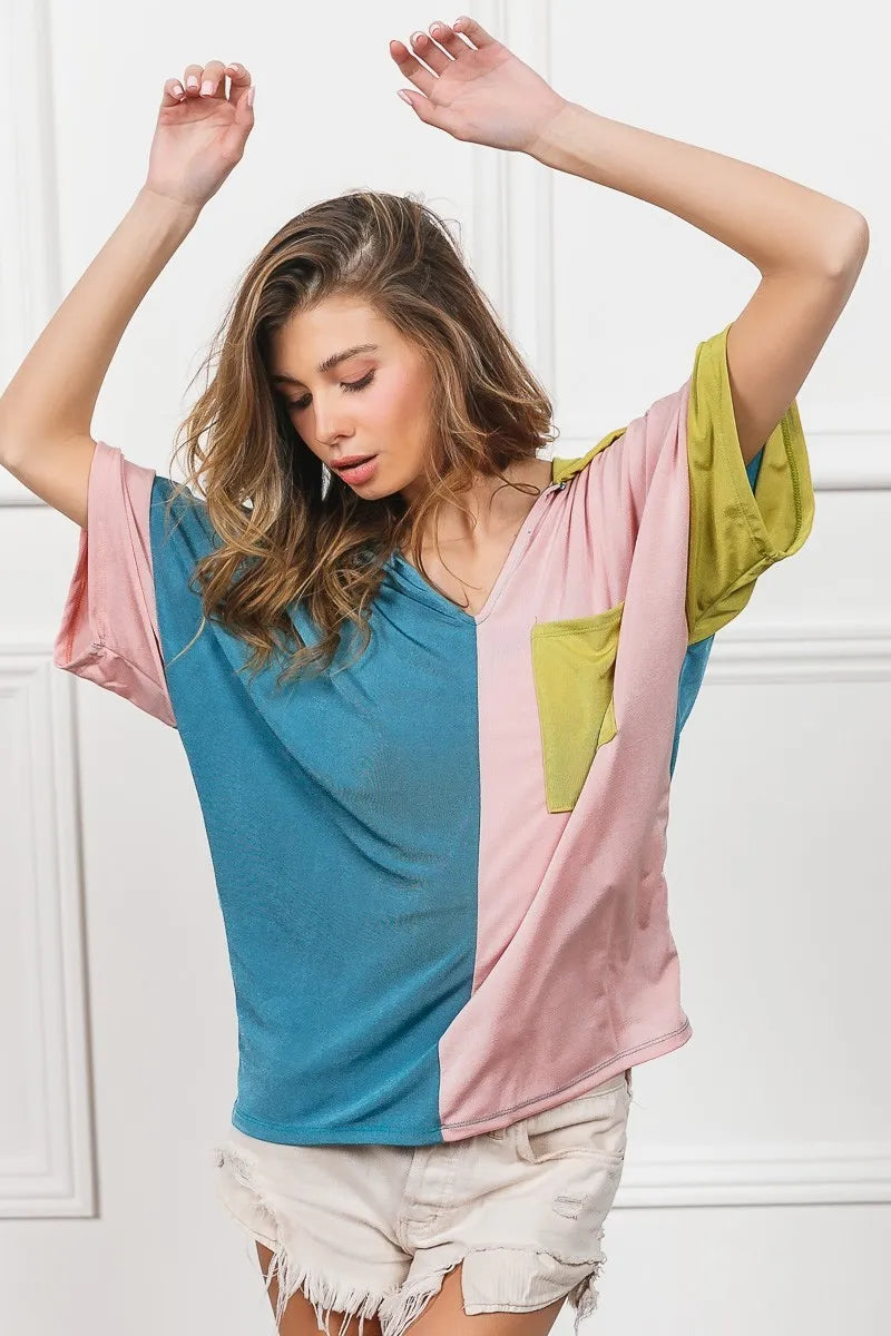 Color-block V-neck slinky knit top with green pocket and sleeve, teal and pink front