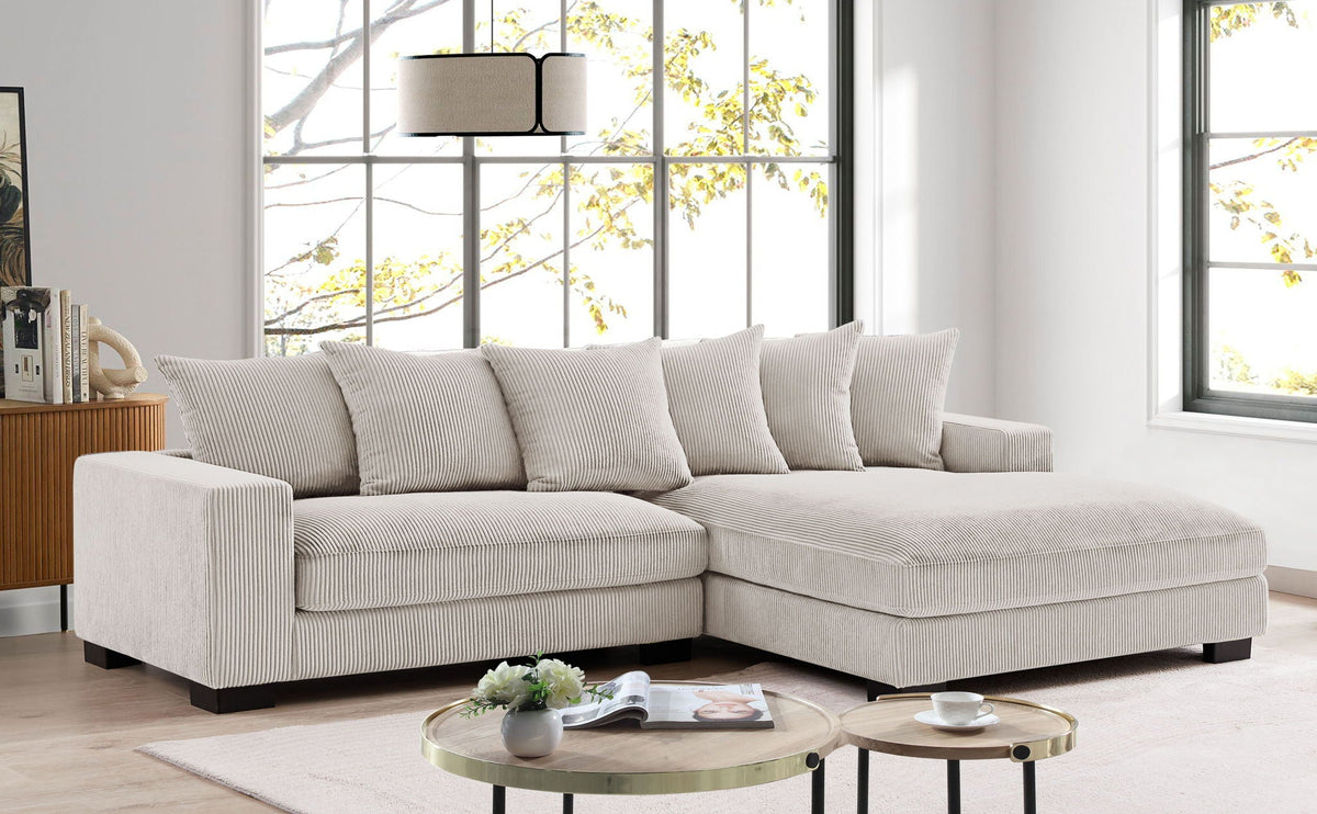 Light gray L-shaped sectional sofa with chaise and five neutral throw pillows.